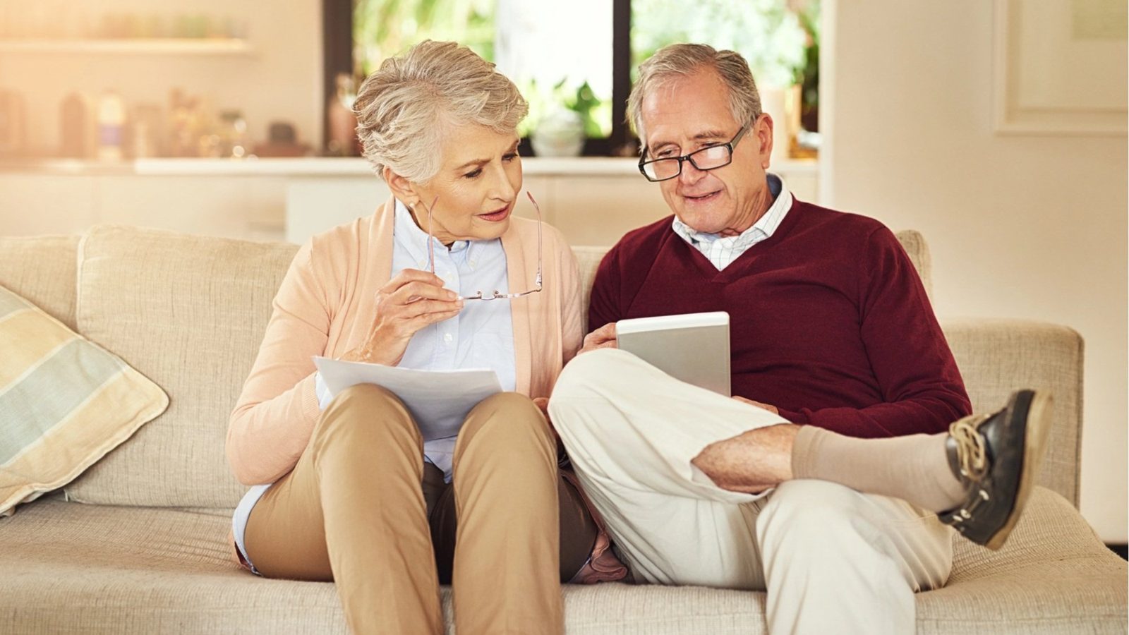 Happy couple on a couch reviewing financing documents